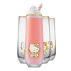 Clear flutes with a golden Hello Kitty logo and golden rims filled with pink drink and whipped cream on a white background