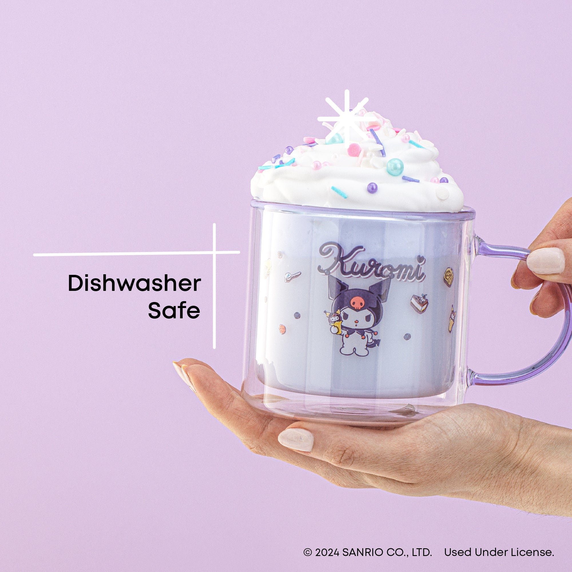 A person holding a clear glass mug with a Kuromi graphic and logo. The mug has whipped cream. Text on the image reads, "Dishwasher Safe."