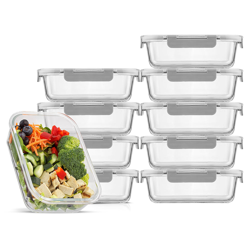 A set of clear glass food storage containers with grey airtight lids, displayed in a stacked fashion with one container in the front containing a colorful salad.