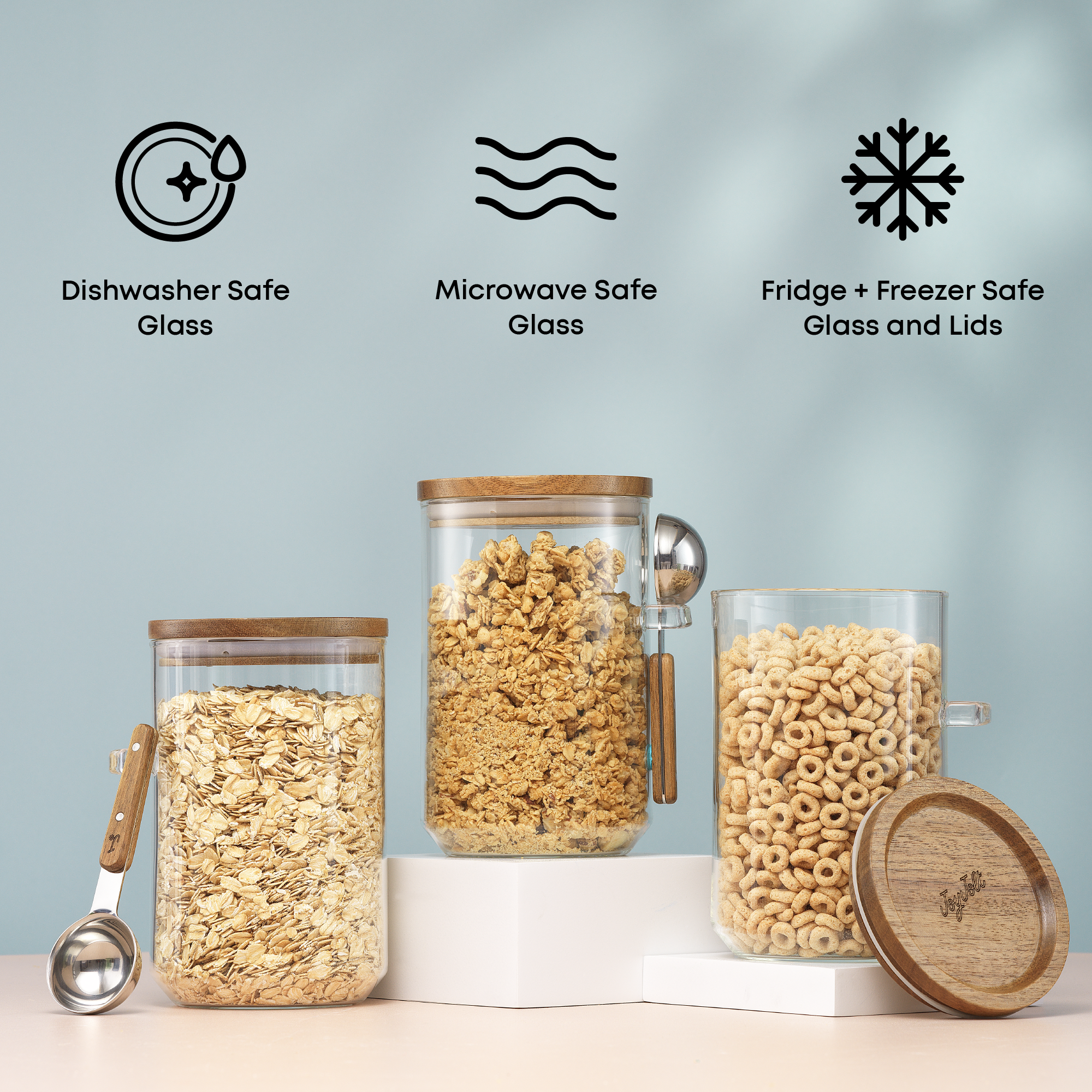Glass storage canisters with wooden lids containing cereals, with safety icons and text on a light blue background: "dishwasher and microwave safe glass, fridge and freezer safe glass and lids"