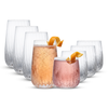 Six clear textured drinking glasses arranged in a fan shape on a white background, with two glasses in front filled with pink beverages and garnished with orange curls.