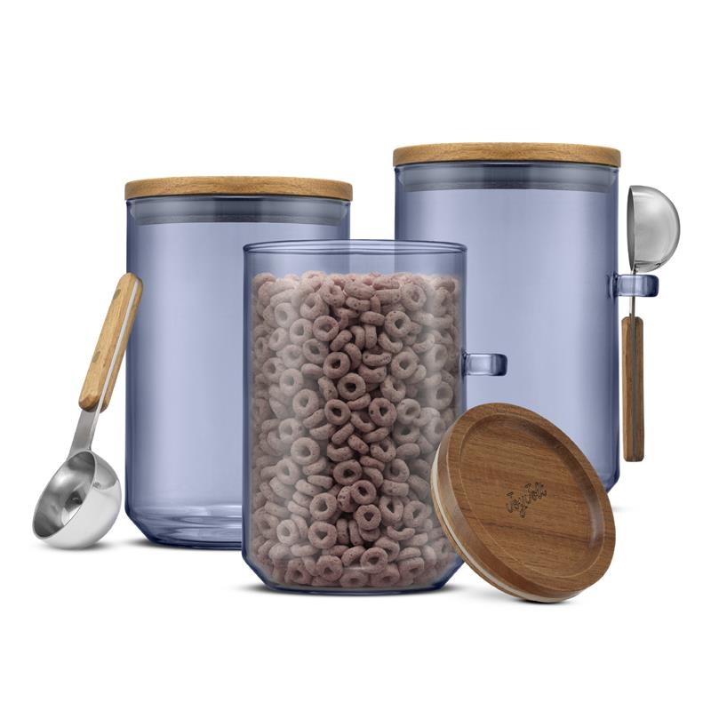 Blue colored glass storage canisters with wooden lid and spoon, filled with cereal on a white background.