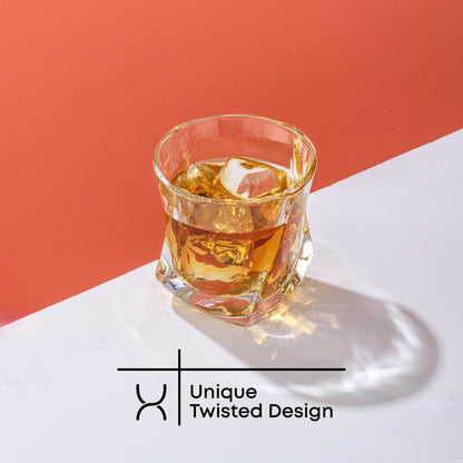 A JoyJolt Aurora Whiskey glass filled with whiskey and ice on a red and white background. Text on image reads, “Unique Twisted Design.”