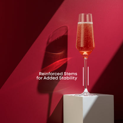 A champagne glass full of champagne on a white stand against a red background with text saying reinforced stems for stability.