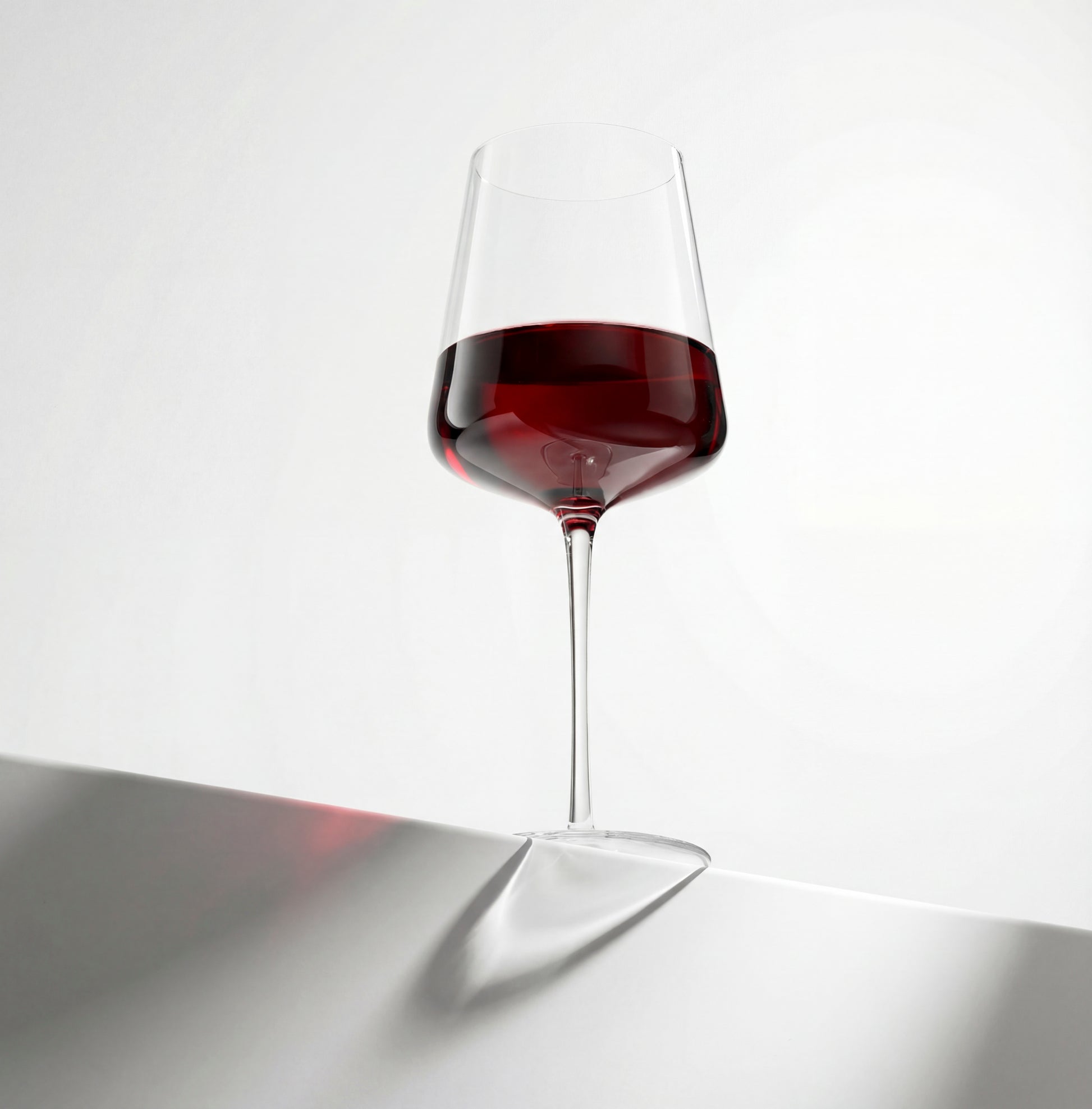 Wine glass with red wine on a reflective surface