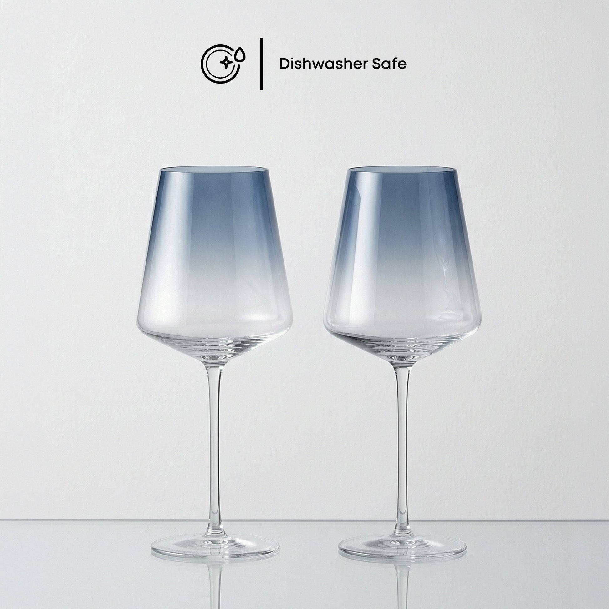Two dishwasher-safe glass wine glasses on a light gray background
