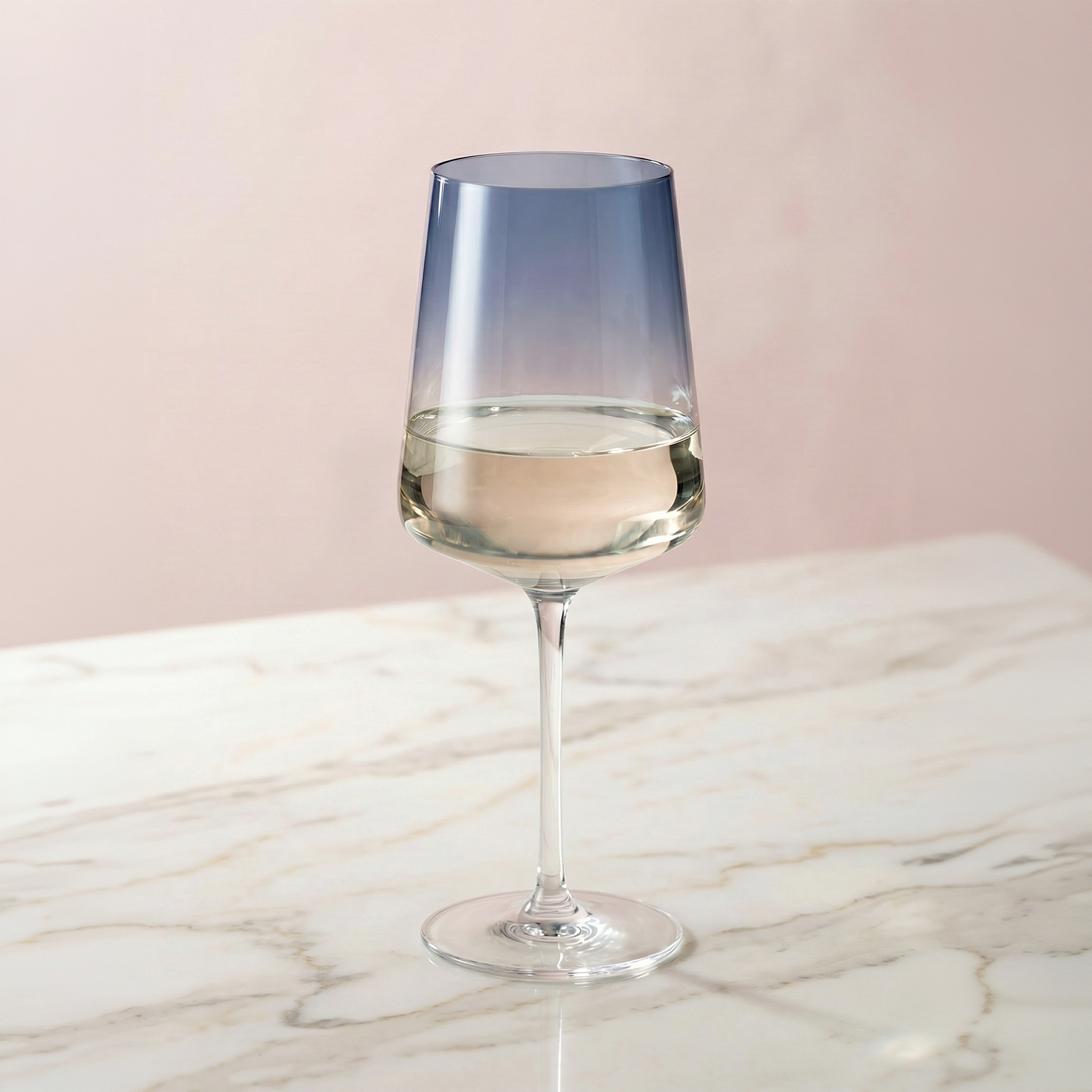 Blue gradient wine glass with white wine on a marble surface