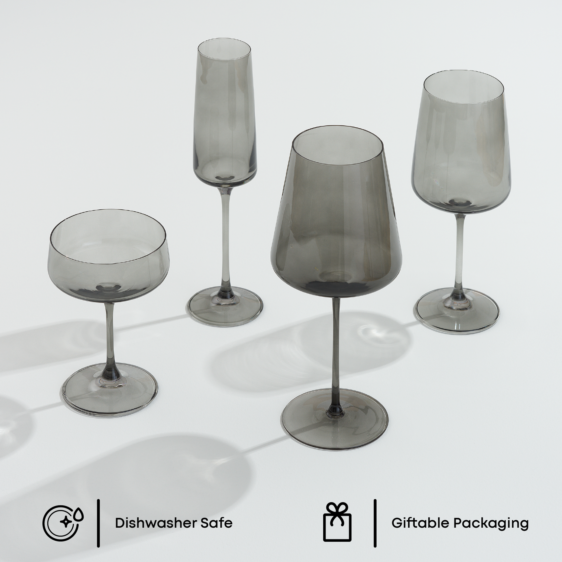 Set of smoked glass stemmed glasses on a white background with 'Dishwasher Safe' and 'Giftable Packaging' icons.