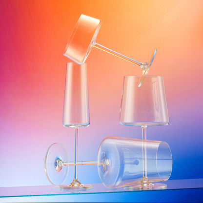 Set of clear crystal stemmed glasses on a gradient background.