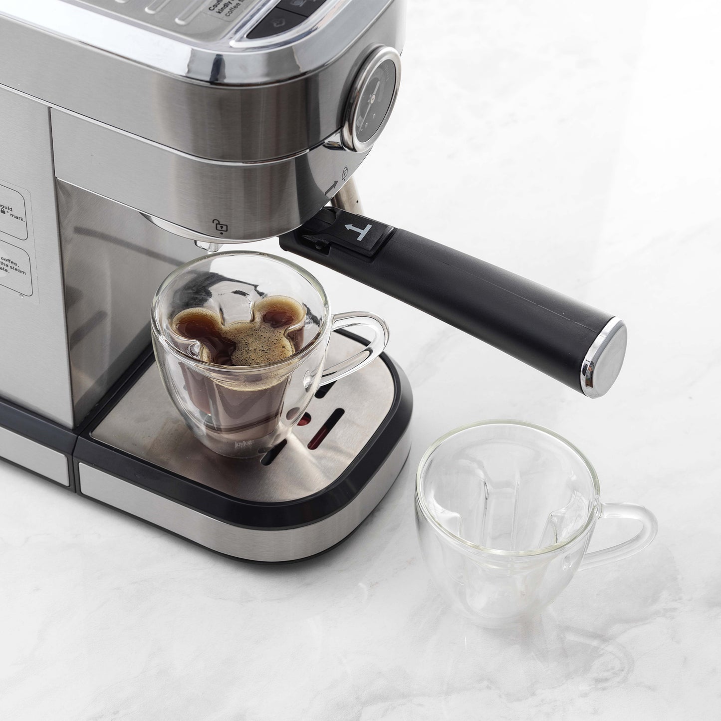 A mickey espresso mug placed under a coffee maker