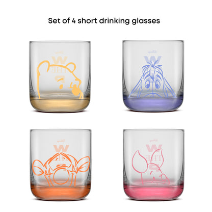 Set of 4 short drinking glasses with colorful character designs of Pooh, Piglet, Eeyore and Tigger on a white background