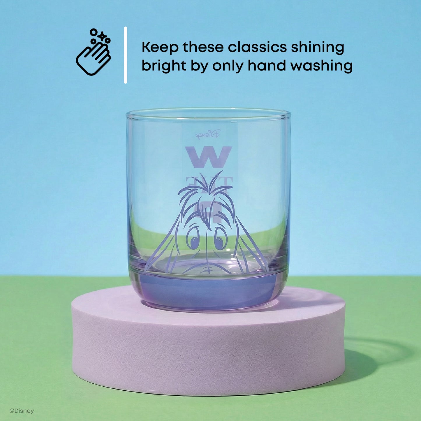 Clear glass with a character design of Eeyore in purple on a purple platform against a blue and green background with text: "keep these shining bright by only handwashing"