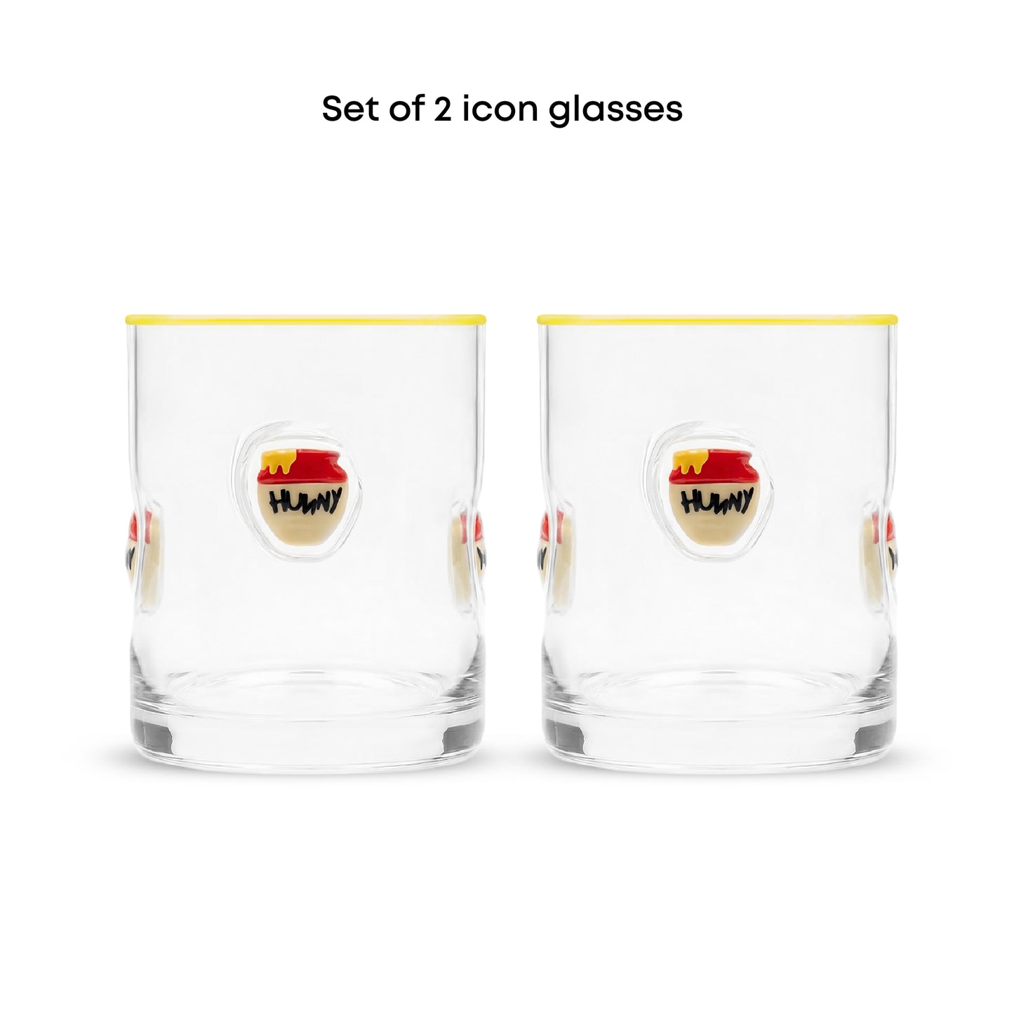 Set of 2 clear glass tumblers with a yellow rim, featuring a cartoon honey pot illustration on the front with the text 'HUNNY' and the caption 'Set of 2 icon glasses' above.