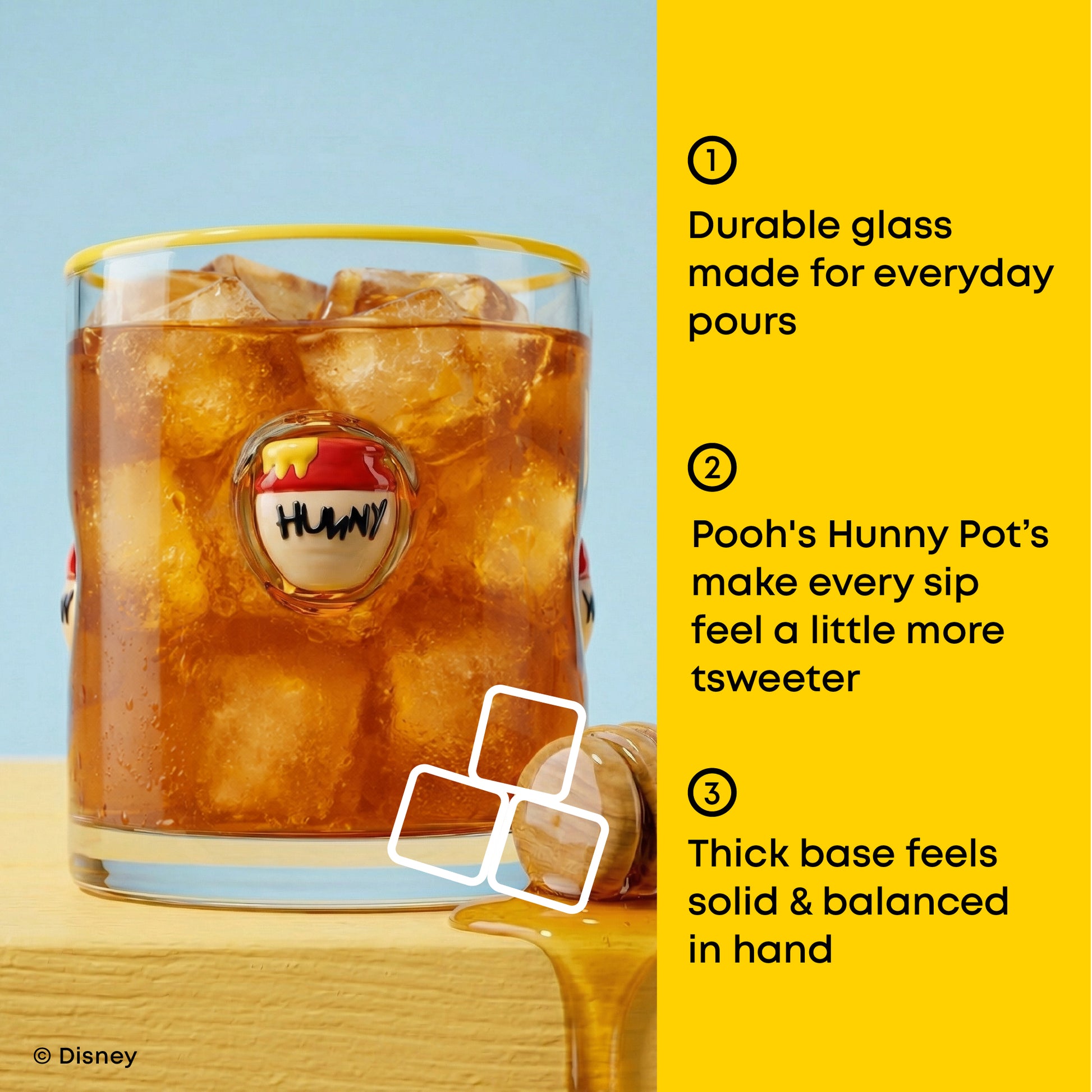 A clear glass tumbler with a yellow rim and a round Pooh's Hunny logo medallion, filled with iced amber drink and ice cubes, set on a wooden surface against a light blue background. A bright yellow text panel on the right lists three feature callouts with numbers.