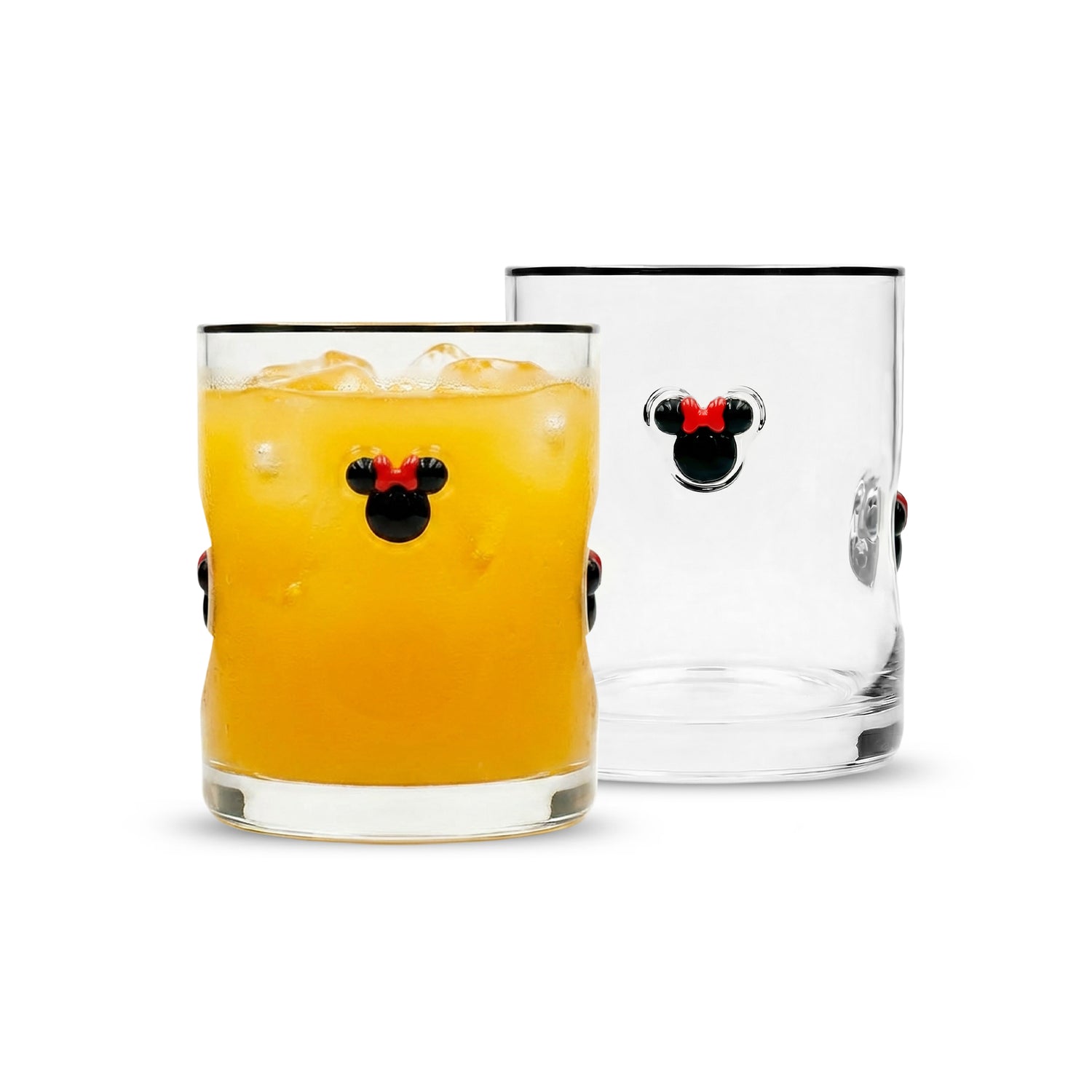 Two clear glass tumblers with black rims and a black-and-red Mickey Mouse head motif on the front, shown on a white background. One tumbler is filled with an orange drink and ice, and the other is empty.