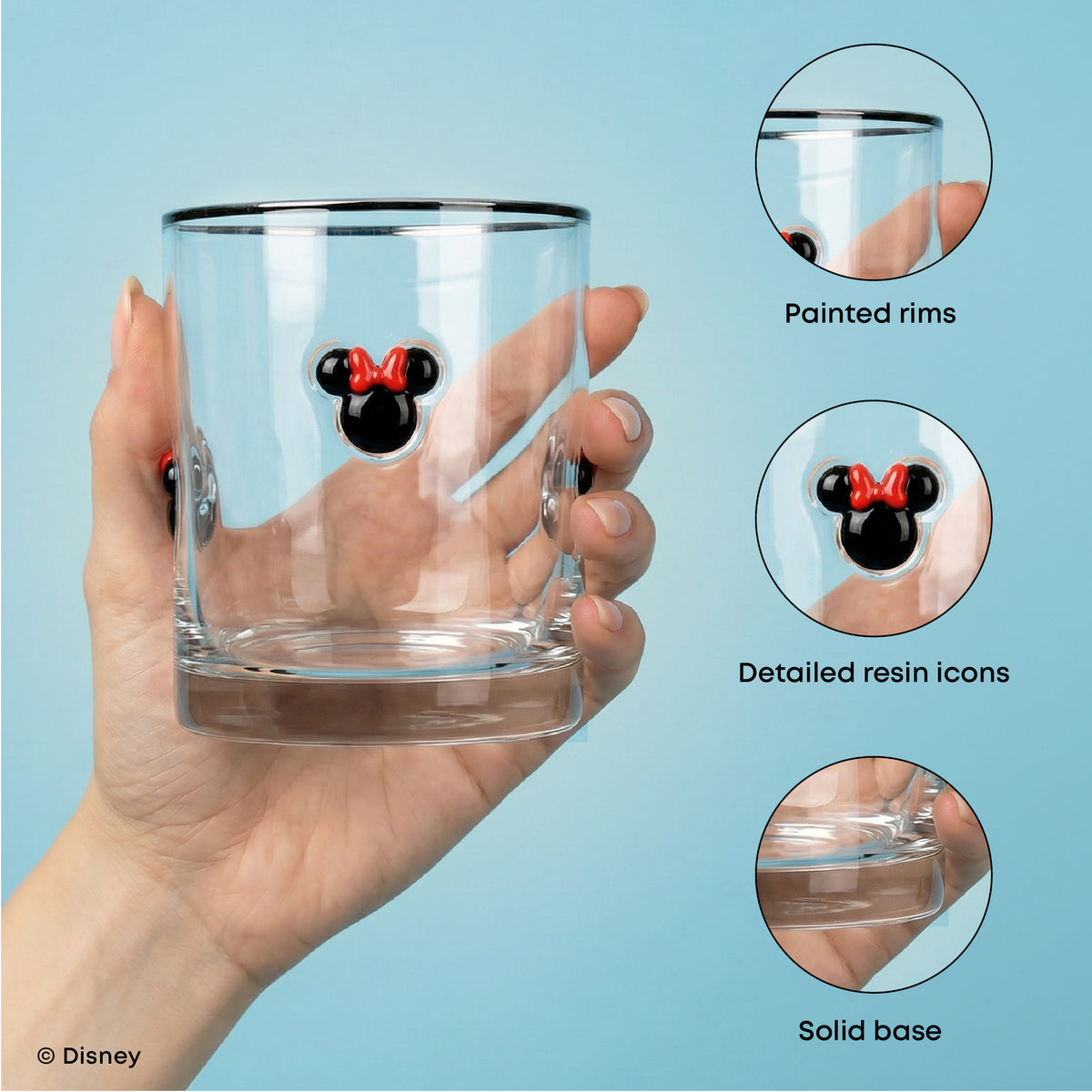 A hand holds a clear glass tumbler with a Mickey Mouse head icon on the front, featuring black painted rims and a solid base. Three circular inset callouts on the right highlight product details: painted rims, detailed resin icon, and solid base.