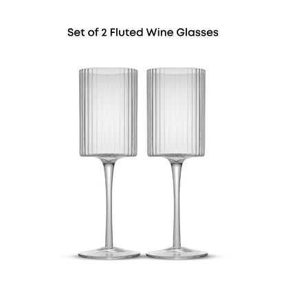 A set of two clear, tall wine glasses with fluted cylindrical bodies and single stems.