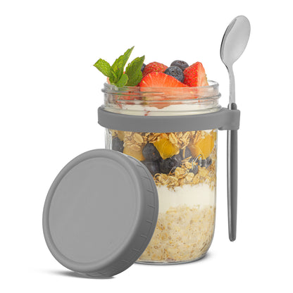 JoyJolt grey overnight oats container and spoon filled with fruit, granola, and yogurt.
