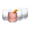 Set of four clear glass tumblers with a pink cocktail and orange slice on a white background