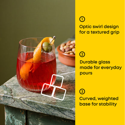 Glass with a cocktail and garnish on a wooden surface, with text about glass features.