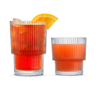 Two glasses of red cocktails with orange slices on a white background