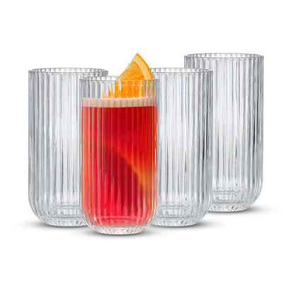 Clear glass tumblers with a red beverage and orange slice on a white background