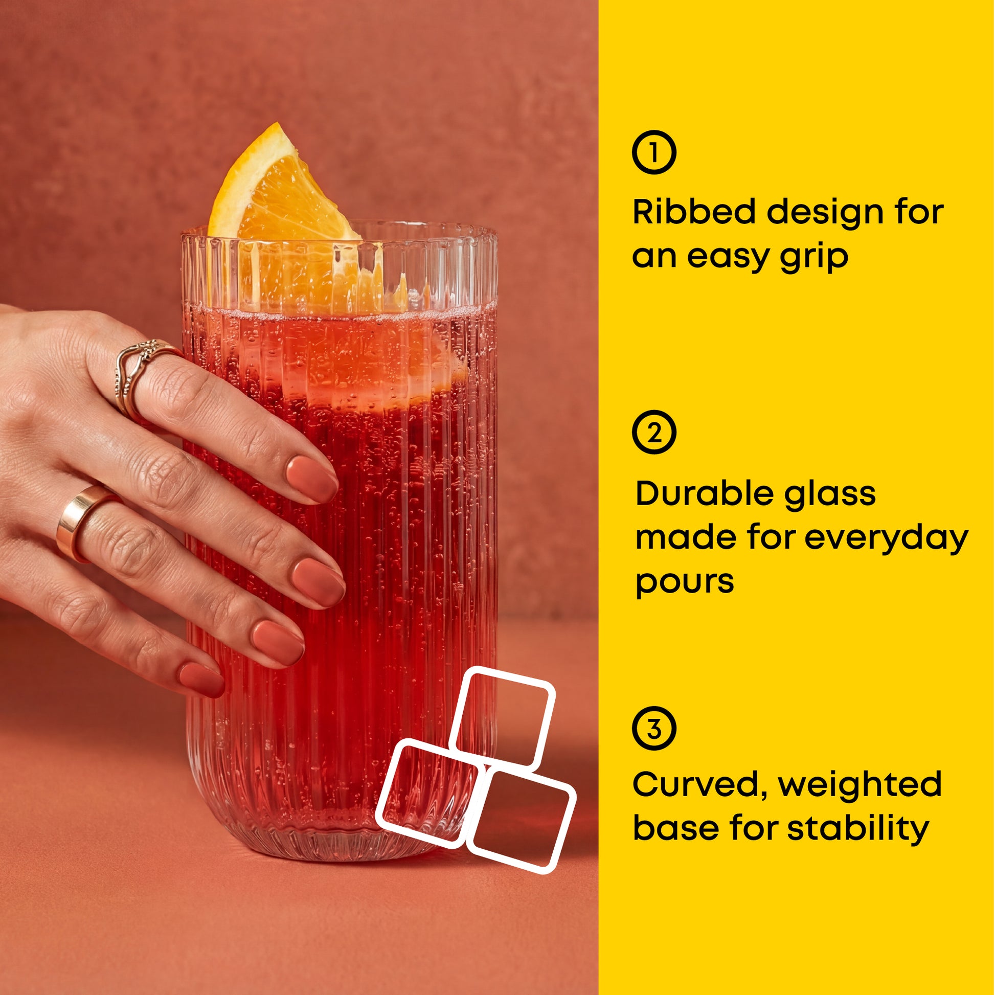 Glass with a ribbed design, durable glass, and curved base held by a hand on a red background.