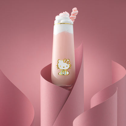 A Hello Kitty themed stemless flute filled with a pink beverage, presented against a pink backdrop.