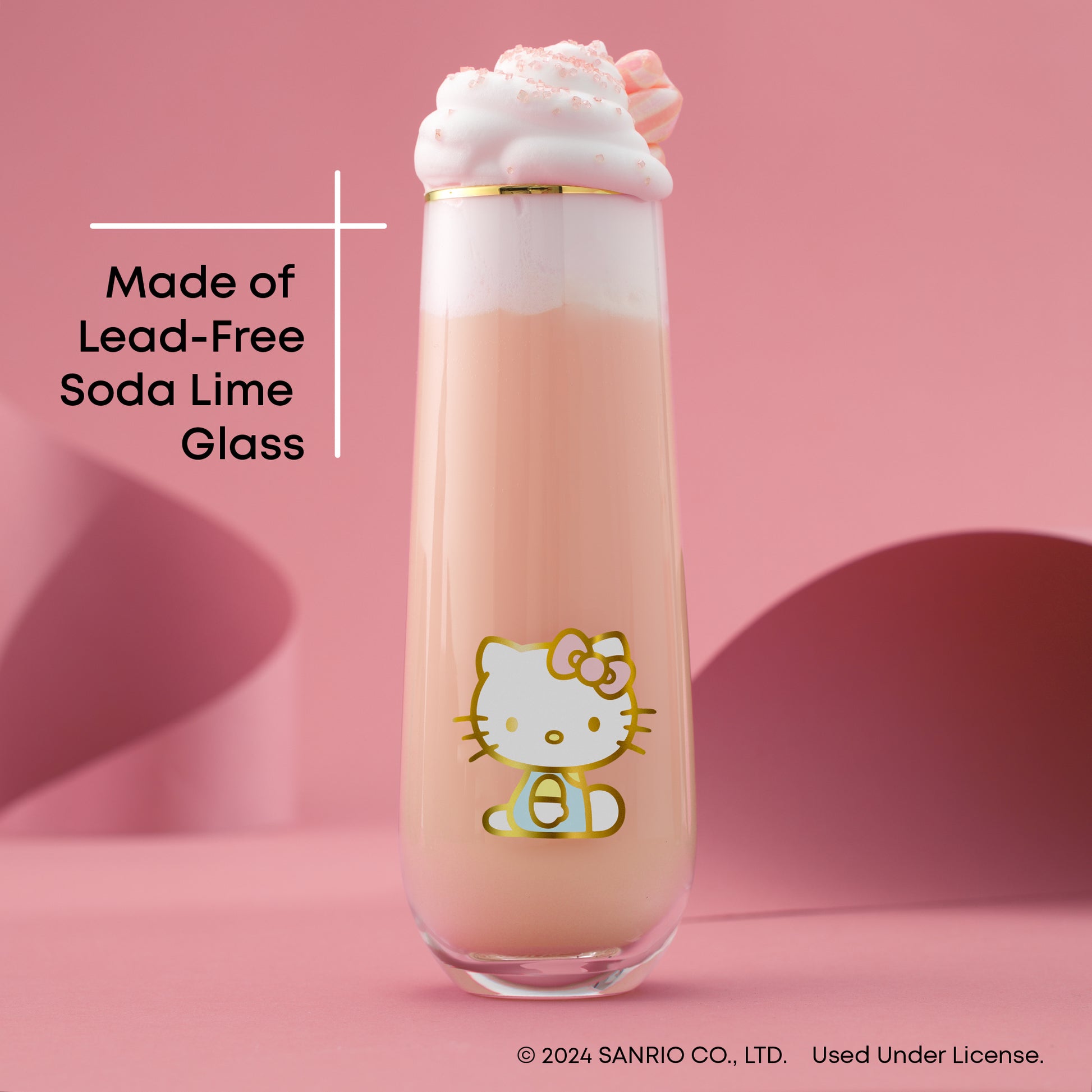A Hello Kitty themed stemless flute filled with a pink beverage, presented against a pink backdrop, with text "made of lead free soda lime glass"