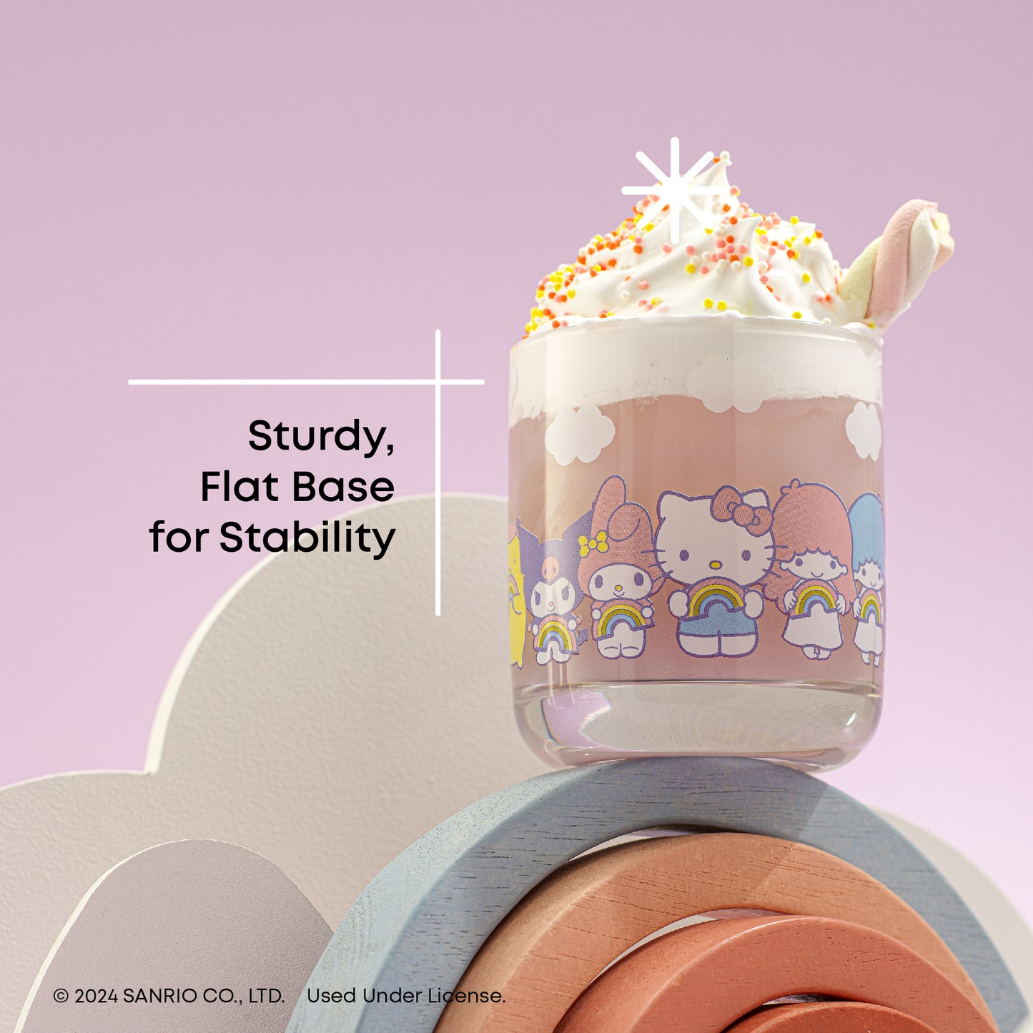 A set of four Hello Kitty themed short drinking glasses with a rainbow design, displayed against a pastel background, with text "sturdy, flat base for stability"