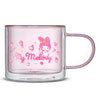 A pink glass mug with a white image of My Melody, a little cartoon rabbit wearing a red hooded cloak and holding a pink purse. Text on the mug reads  “Strawberry Milk.” The mug is from a collaboration between JoyJolt and Sanrio.