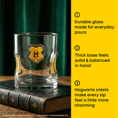 A clear glass tumbler with a yellow and black Hogwarts crest emblem sits on a dark book against a green curtain background. A bright yellow text panel on the right lists product features in numbered points.
