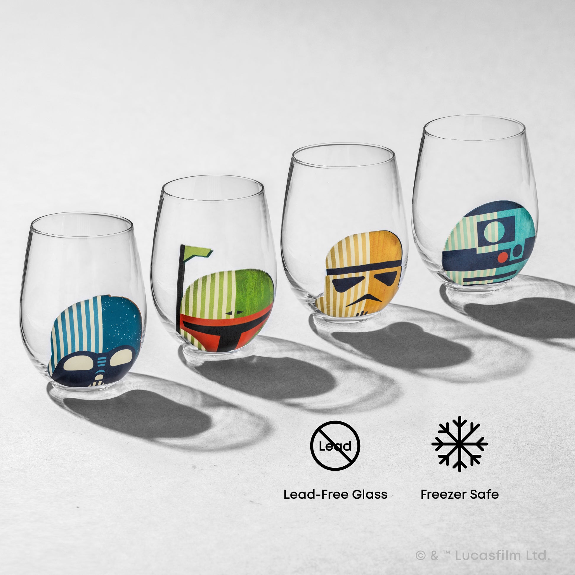 Four stemless wine glasses with colorful Star Wars character helmet designs on a white background, each glass showing either R2-D2, darth vader, stormtrooper, or boba fett. With text "lead free glass and freezer safe"