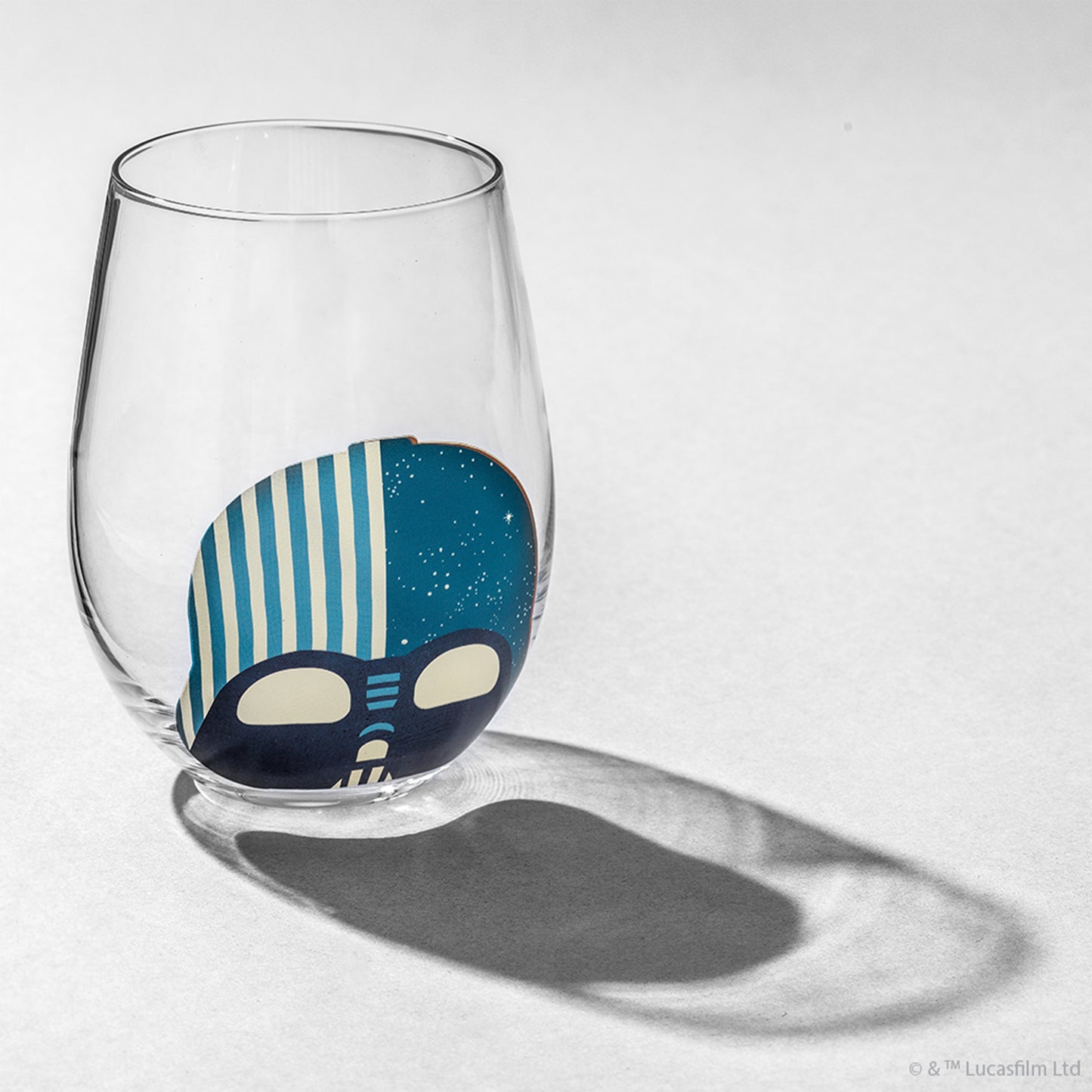 A stemless clear glass with Darth Vader helmet design against a white background.