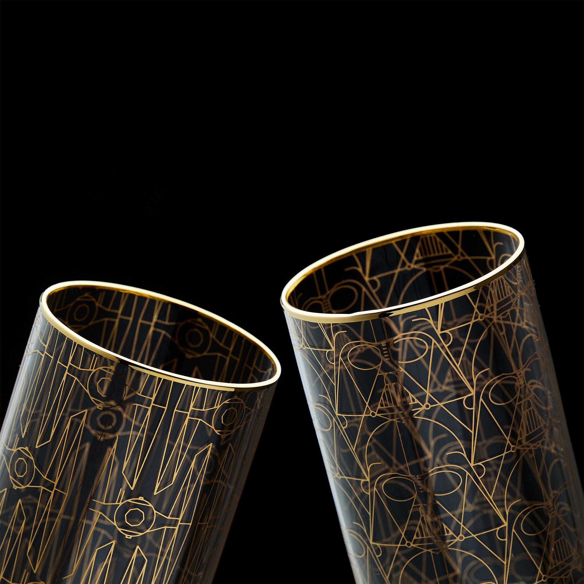Close up image of Darth Vader and TIE fighter glasses against a black background, highlighting their gold rims on both glasses.