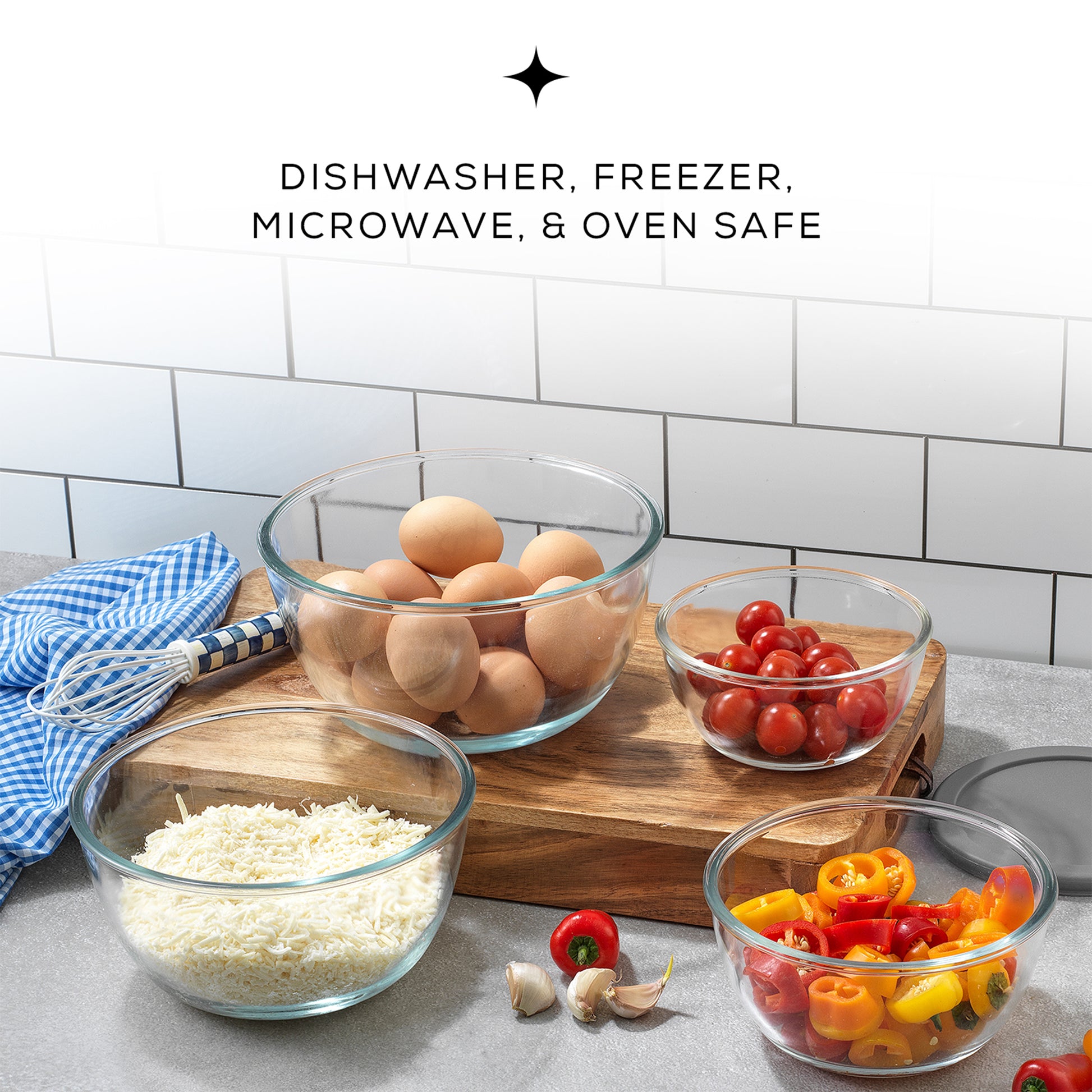 A wooden cutting board holds four glass bowls filled with colorful vegetables and eggs. Text overlay reads  “DISHWASHER, FREEZER, MICROWAVE, & OVEN SAFE”. 