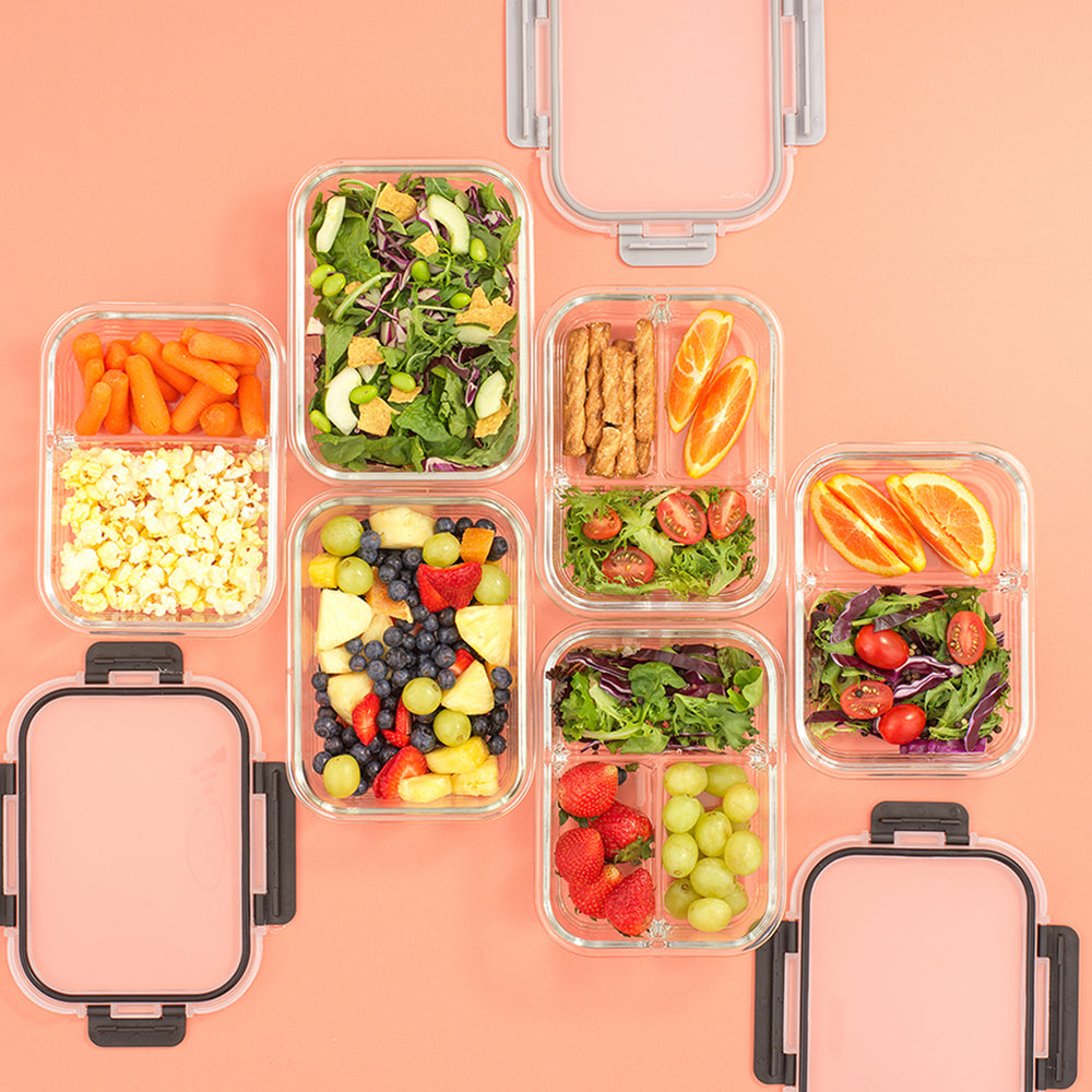 Assortment of foods stored in containers: salad, pretzel, popcorn, fruit.
