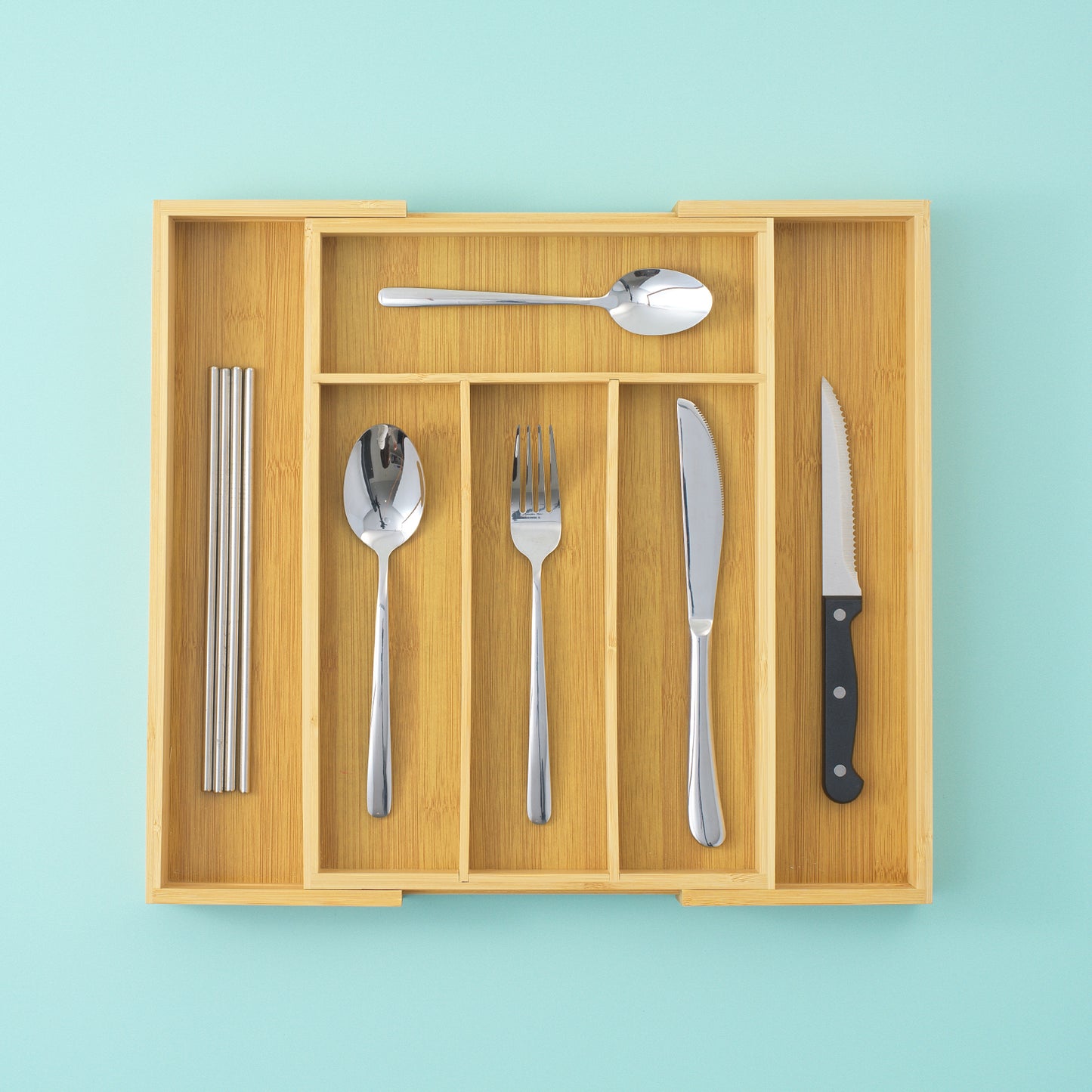 A drawer organized expanded with 6 slots, with straws, spoons, forks, and knives organized neatly in their slots