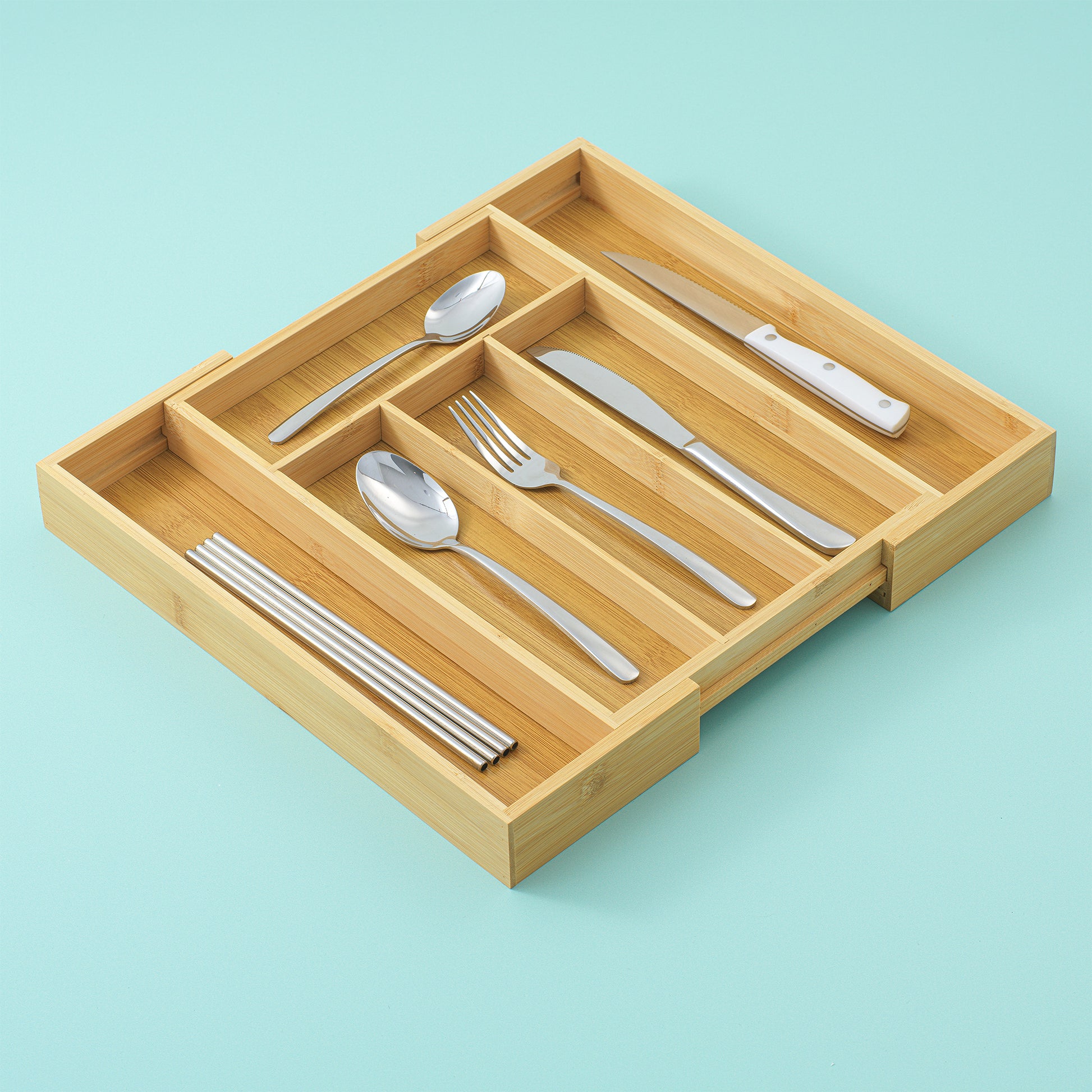 A drawer organized expanded with 6 slots, with straws, spoons, forks, and knives organized neatly in their slots