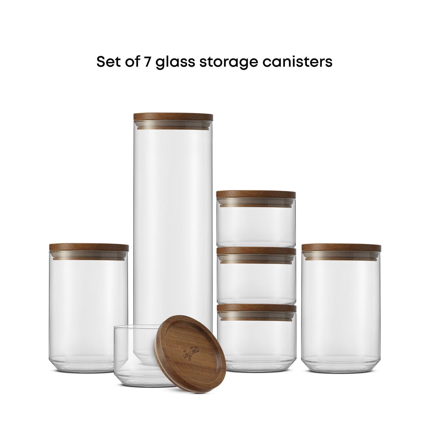 Set of 7 glass storage canisters with wooden lids on a white background