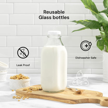 A reusable glass bottle filled with milk stands on a wooden cutting board in a bright kitchen setting. Text and icons highlight product features: 'Reusable Glass bottles,' 'Leak Proof,' and 'Dishwasher Safe.