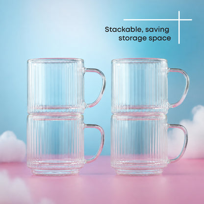 Four clear ribbed glass mugs with handles, stacked in two pairs of two, on a pastel pink and blue background with clouds and the text 'Stackable, saving storage space'.