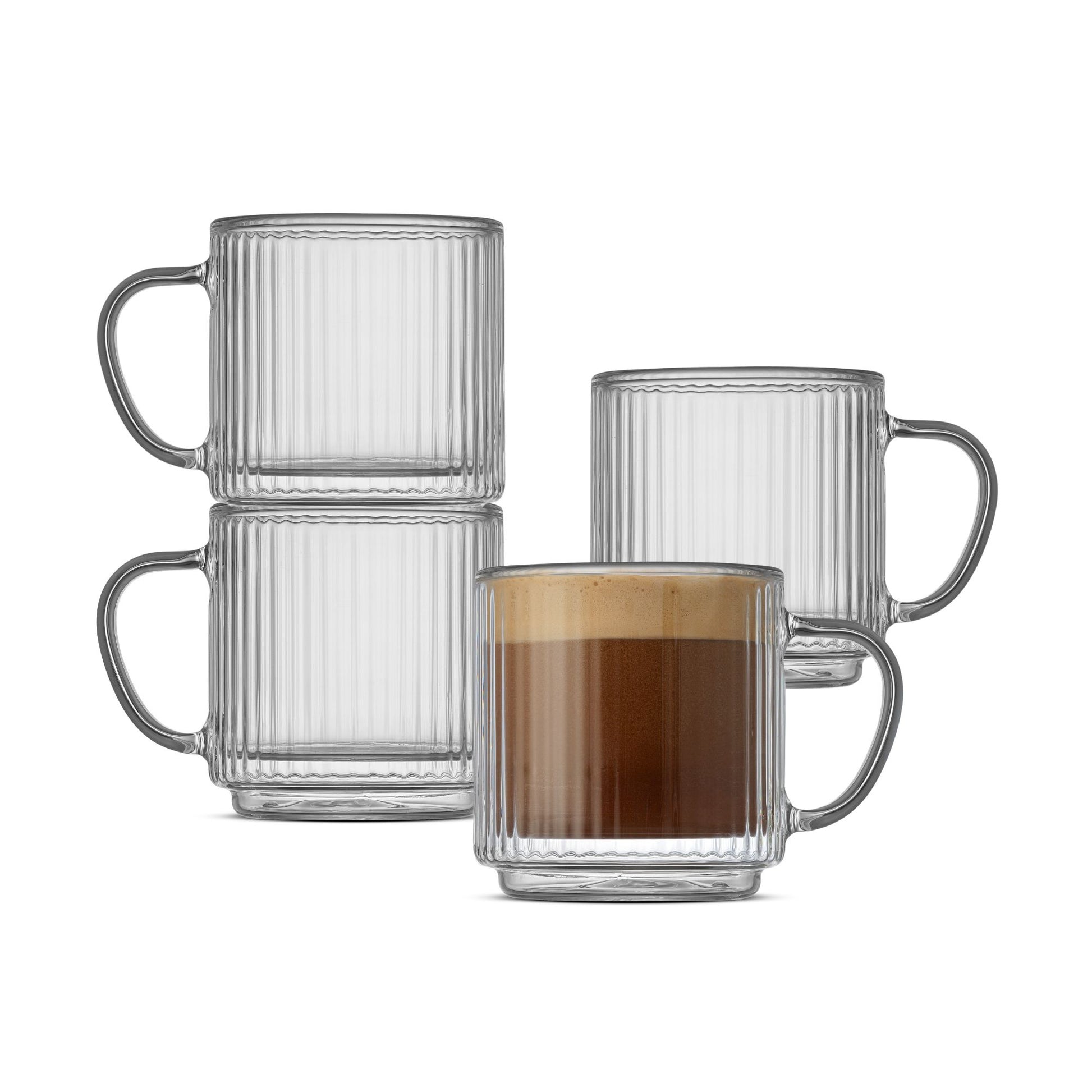 Four clear ribbed glass mugs with handles, including two stacked empty mugs, one empty mug behind, and one mug filled with a coffee drink, on a white background.