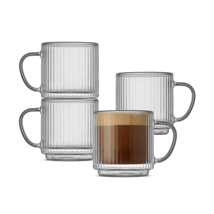 Four clear ribbed glass mugs with handles, including two stacked empty mugs, one empty mug behind, and one mug filled with a coffee drink, on a white background.